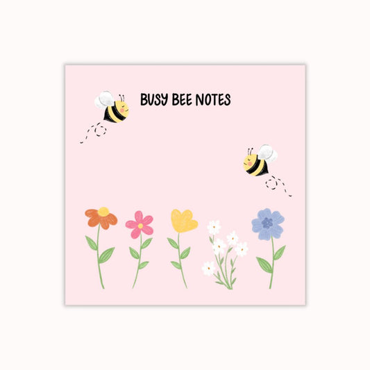 Hand-illustrated pink sticky notepad adorned with bumble bees and flowers, featuring the label 'Busy Bee Notes'.